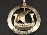 un pendentif en or avec un bateau au centre