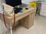 un bureau sur lequel se trouvent un ordinateur portable, un clavier, une souris et un sac