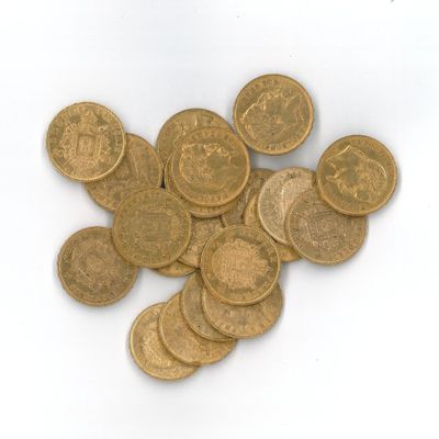 une pile de pièces d'or posée sur une surface blanche