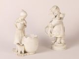 une paire de statues blanches représentant des enfants arrosant une jardinière