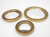 three gold plated mirrors with ornate designs on them on a white surface