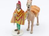 a figurine of a man and a donkey on a white surface