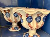 deux vases posés sur une étagère dans une pièce carrelée de bleu