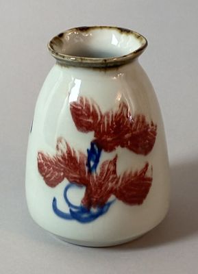 a white vase with a red and blue design on it