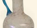 a white vase with a blue handle on a white background