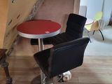 a black chair and a red table in the corner of a room