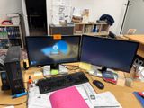 un bureau sur lequel sont posés deux écrans d'ordinateur et un clavier