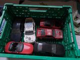 de nombreuses petites voitures dans une caisse verte posée sur un lit