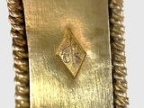 a close up of a gold plate with a diamond on it