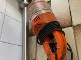 une photo d'une ponceuse à main orange dans une salle de bains