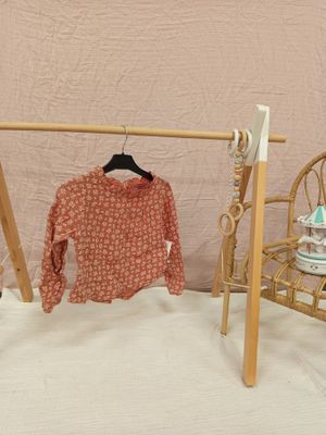 un portant sur lequel est accrochée une chemise, avec une chaise à côté