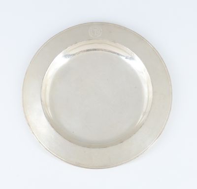 une photo d'une assiette en argent posée sur une table blanche
