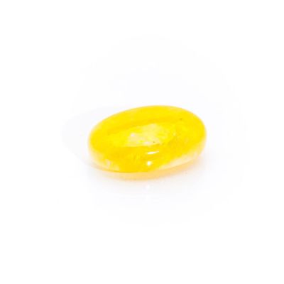 a close up of a yellow jelly on a white surface