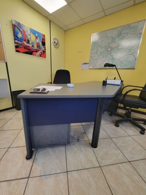 un bureau et des chaises dans une pièce où est accrochée une carte au mur
