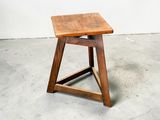 une photo d'un petit tabouret en bois dans une pièce