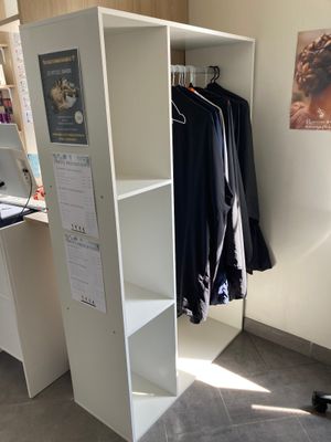 un placard avec des vêtements sur les étagères dans la pièce