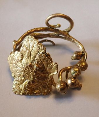 un bracelet en or orné d'une feuille et de perles