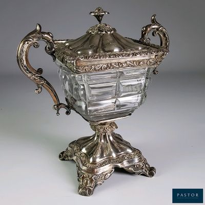 un vase en argent muni d'un couvercle et posé sur un socle