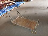 a small cart with a wooden handle in a warehouse