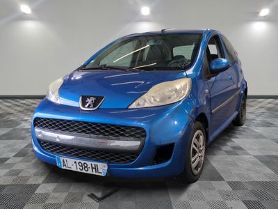 La petite voiture bleue est garée dans le garage, sur le sol à carreaux.