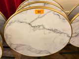 four round marble tables with gold rims on them