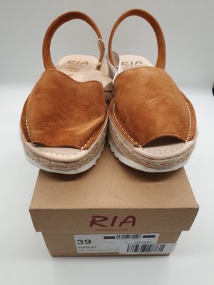 les chaussures se trouvent dans une boîte posée sur une surface blanche