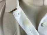 a close up of a white shirt with a hole in the collar