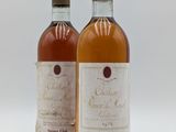 deux bouteilles de vin posées l'une à côté de l'autre sur une surface blanche