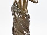 an antique bronze statue of a woman with a draped dress