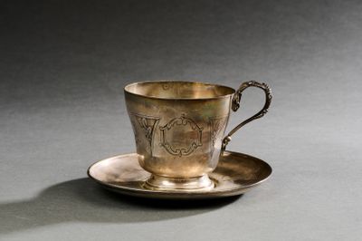 une tasse et une soucoupe en argent posées sur une table