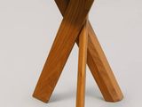 a close up of a small wooden table with two crossed legs