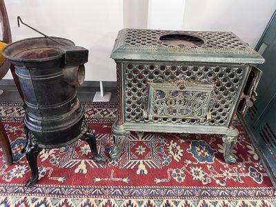 une paire de poêles anciens en fonte posés sur un tapis dans une pièce