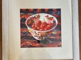 painting of a bowl of strawberries in a white frame on a wooden table