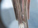 a close up of a silver spoon with a hole in it