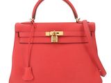 a red leather handbag with a gold lock on the handle