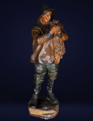 statue en bronze représentant un homme tenant un chien dans ses bras