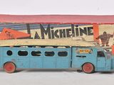 un petit bus bleu avec une boîte posée dessus
