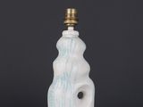 a white and blue ceramic lamp with a small light bulb on top of it