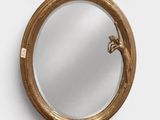 un miroir rond sur lequel est représenté un oiseau et un oiseau sur le miroir