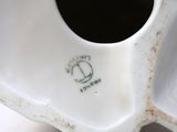 a close up of a white vase on a table