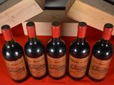 six bottles of red wine are lined up on a red table