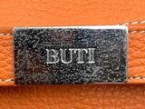 an image of a close up of a leather bag with the word buti on it