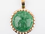 a green jade stone pendant with gold accents on a white background