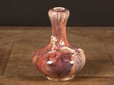 a small vase that is sitting on a wooden table