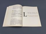 un livre ouvert sur lequel figure une illustration de la lettre « l »
