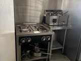 une image d'une cuisine avec une cuisinière et un réfrigérateur
