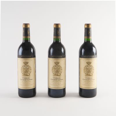 trois bouteilles de vin posées les unes à côté des autres sur une surface blanche