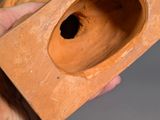 a person holding a clay object with a hole in it