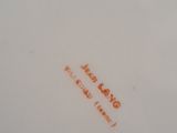 a close up of a white plate with orange writing on it