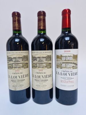 trois bouteilles de vin rouge posées côte à côte sur une table